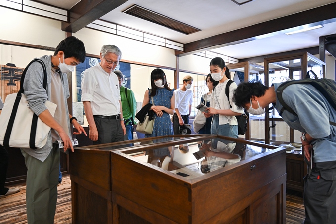 △吉田璋也プロデュースの多数の展示作品を見学する学生たち